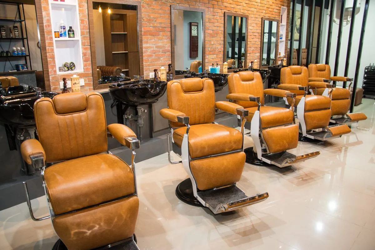 Tan leather barber chairs in a bright, tiled shop