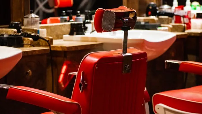 A red vintage barber chair with chrome trim